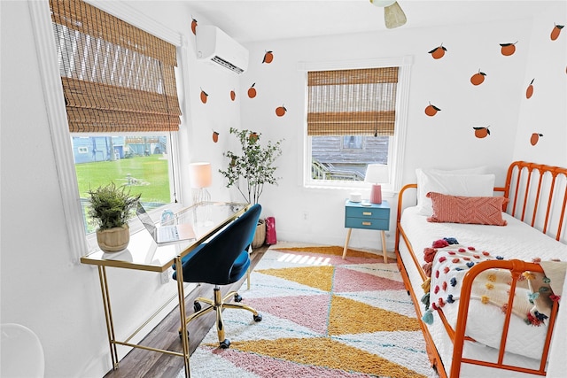 bedroom with multiple windows, baseboards, wood finished floors, and a wall mounted AC