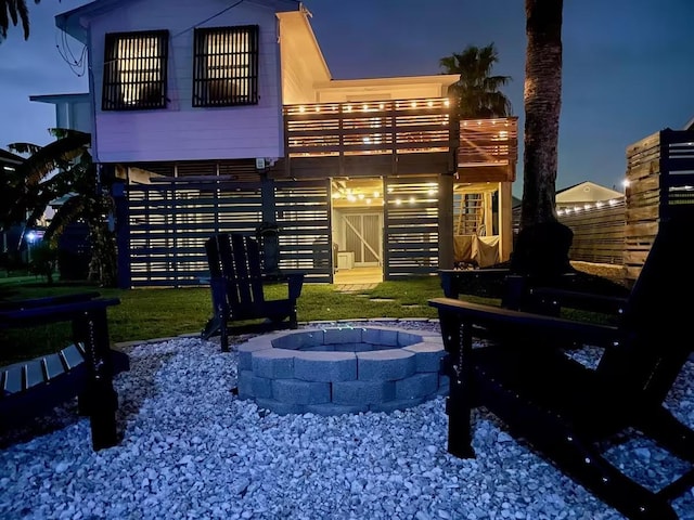 back of house at twilight featuring a fire pit and stairway