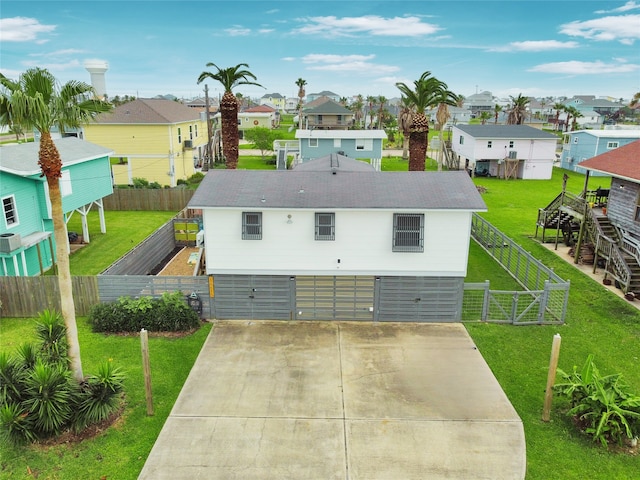 16615 Jamaica Inn Rd, Galveston, TX 77554 - exterior space with a garage, fence, a front yard, concrete driveway, and a residential view