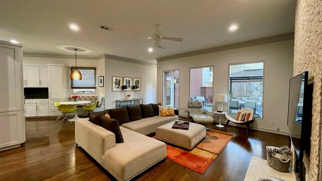 living room with recessed lighting, visible vents, dark wood-style flooring, and ornamental molding