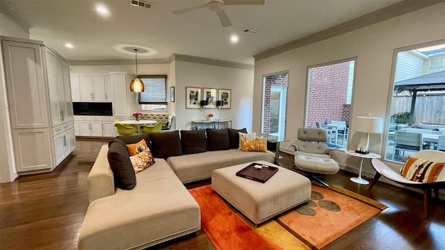 living area featuring visible vents, a ceiling fan, dark wood-style flooring, crown molding, and recessed lighting