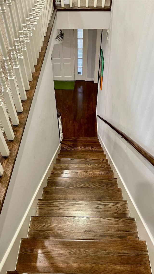 stairway with baseboards and wood finished floors