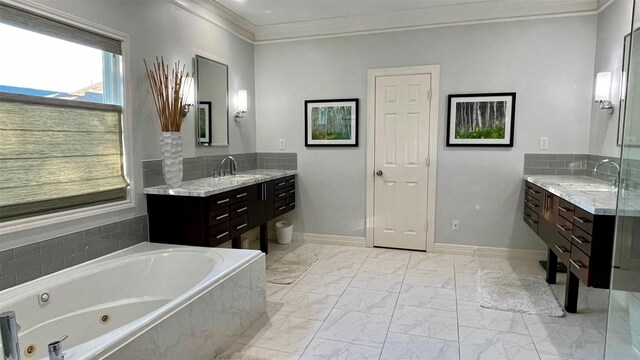 bathroom with marble finish floor, ornamental molding, a jetted tub, and vanity