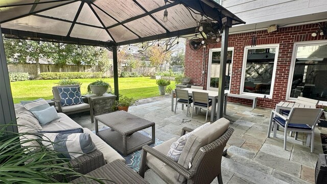 view of patio featuring outdoor dining space, outdoor lounge area, fence, and a gazebo