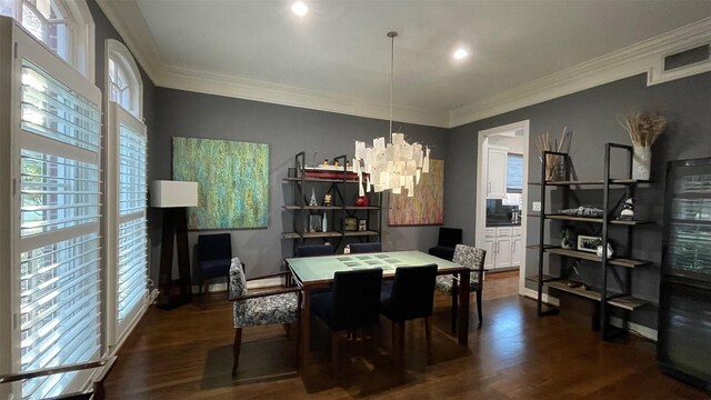 dining area featuring crown molding, a notable chandelier, dark wood finished floors, and visible vents