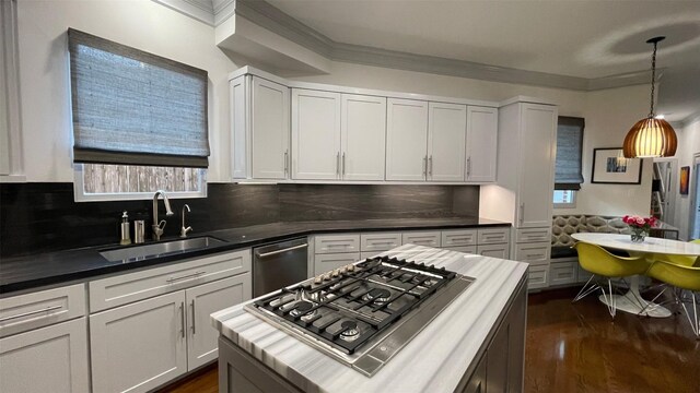 kitchen with dark wood-style floors, appliances with stainless steel finishes, crown molding, white cabinetry, and a sink