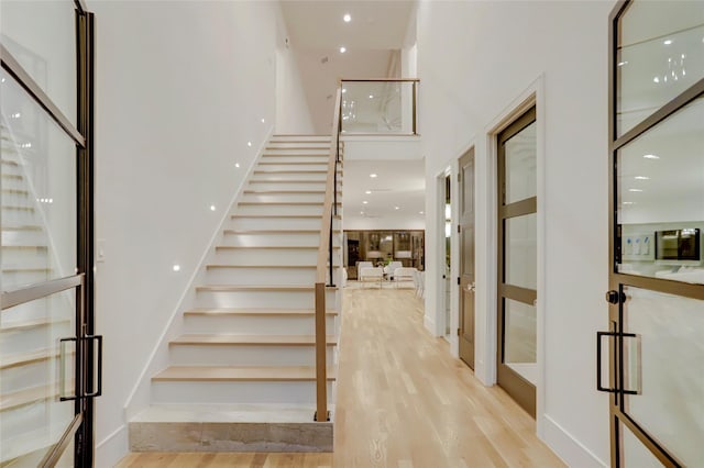 interior space featuring a high ceiling, wood finished floors, and recessed lighting