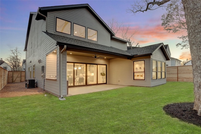 back of house at dusk with a patio area, a fenced backyard, a lawn, and central air condition unit