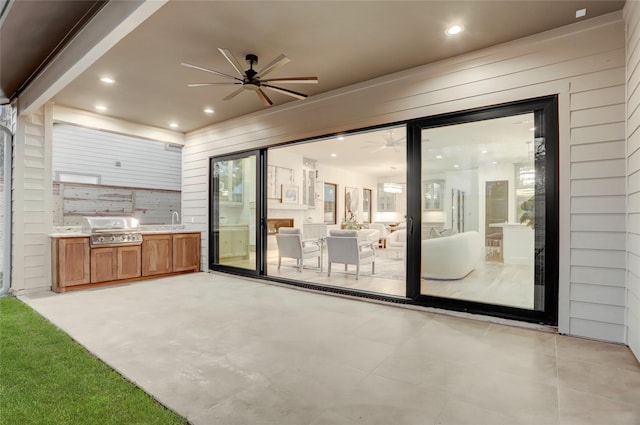 view of patio with a ceiling fan, a sink, a grill, and area for grilling