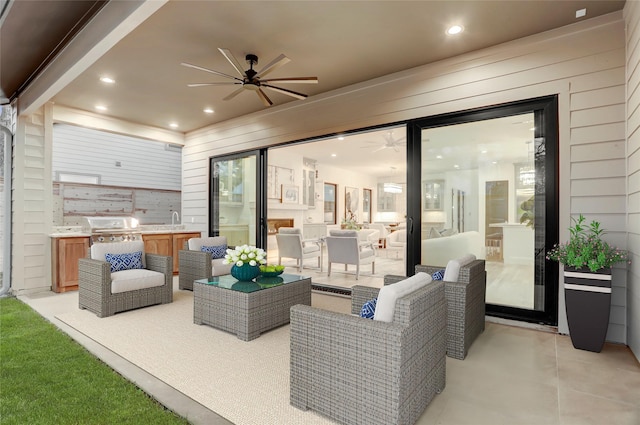 view of patio with an outdoor living space, a sink, a ceiling fan, and a grill