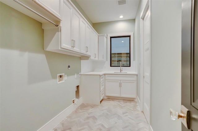 clothes washing area featuring cabinet space, visible vents, gas dryer hookup, hookup for a washing machine, and a sink