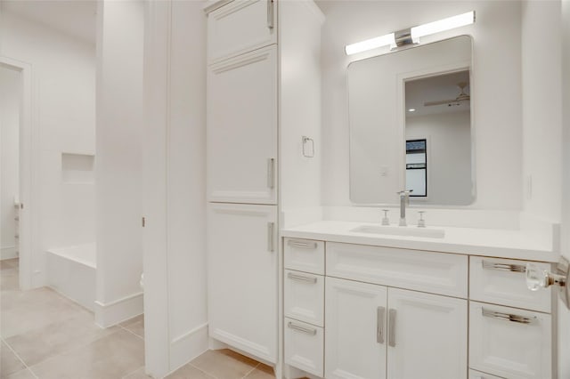 bathroom with a bath, vanity, and tile patterned floors