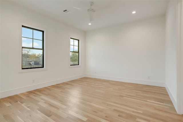 spare room featuring light wood finished floors, baseboards, a ceiling fan, and recessed lighting