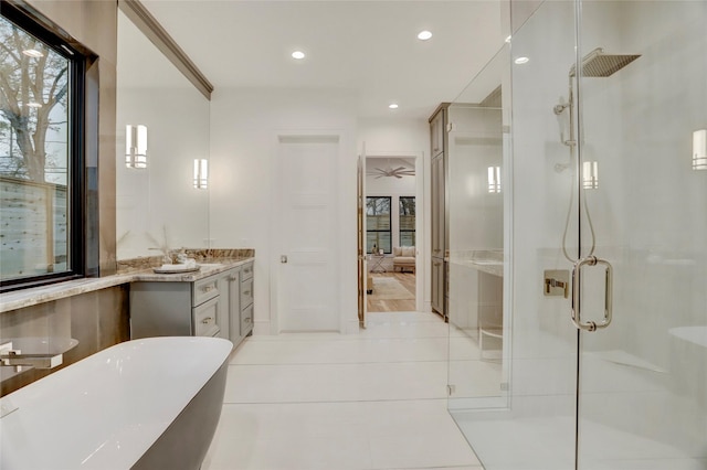 bathroom with a freestanding bath, a shower stall, vanity, and tile patterned floors