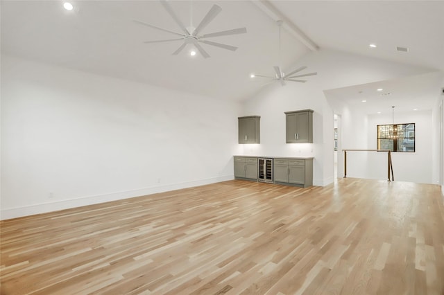 unfurnished living room with wine cooler, beam ceiling, high vaulted ceiling, light wood-type flooring, and ceiling fan with notable chandelier