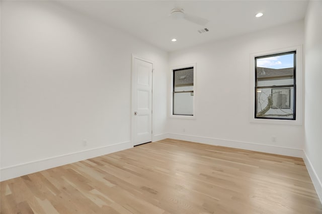 spare room with light wood finished floors, recessed lighting, visible vents, and baseboards