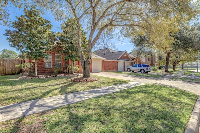 view of front facade with driveway, a garage, brick siding, fence, and a front yard