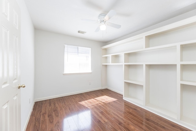 unfurnished room featuring a ceiling fan, wood finished floors, visible vents, and baseboards