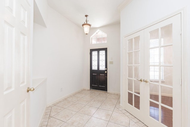 foyer entrance with baseboards, light tile patterned flooring, and french doors