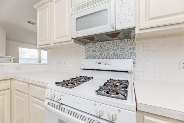 kitchen featuring tasteful backsplash, white appliances, light countertops, and visible vents