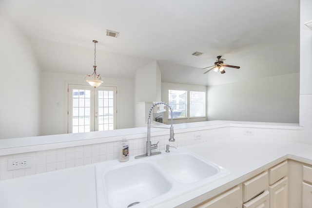 interior space with light countertops, visible vents, a sink, and decorative light fixtures