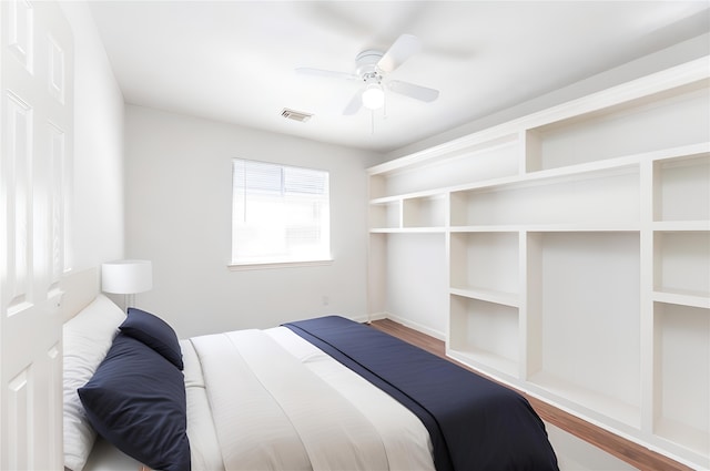 bedroom featuring ceiling fan, wood finished floors, and visible vents