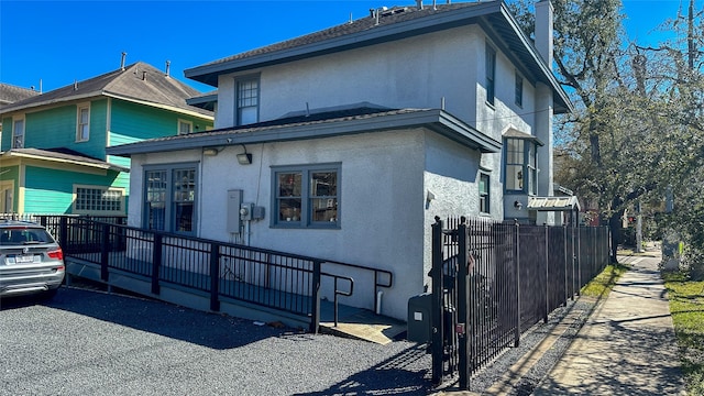 view of side of property featuring fence and stucco siding