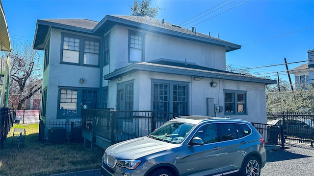 view of front facade featuring fence and stucco siding