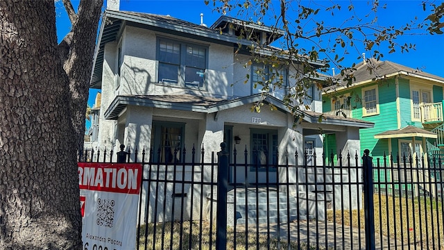 view of front of home featuring a fenced front yard and stucco siding