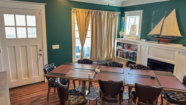 dining area with ornamental molding, a tile fireplace, and wood finished floors