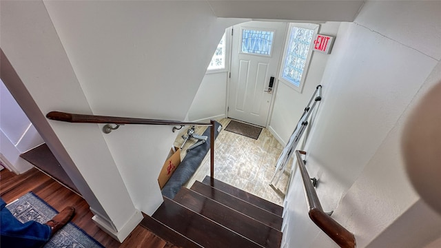 stairway featuring baseboards and wood finished floors