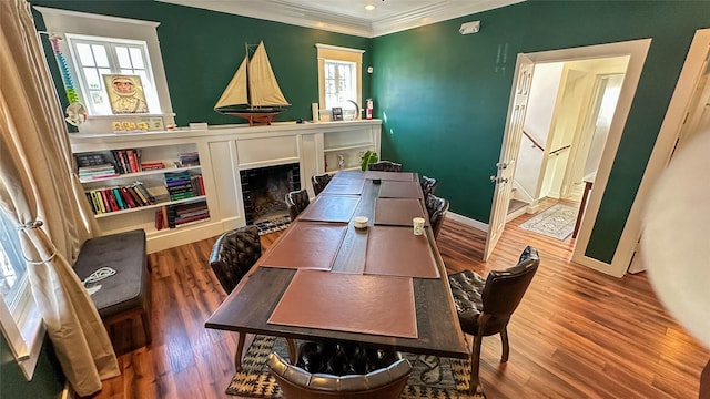 interior space with crown molding, a fireplace, baseboards, and wood finished floors