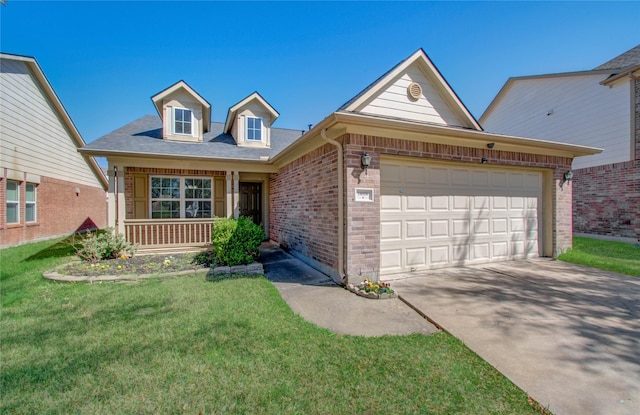 view of front facade with an attached garage, covered porch, brick siding, driveway, and a front lawn