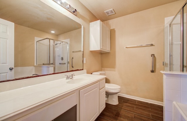 full bathroom featuring toilet, vanity, visible vents, a shower stall, and wood tiled floor