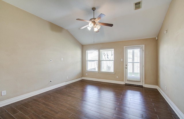 empty room featuring ceiling fan, dark wood-type flooring, visible vents, baseboards, and vaulted ceiling