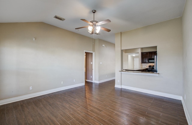 unfurnished room featuring baseboards, visible vents, a ceiling fan, dark wood-style floors, and vaulted ceiling