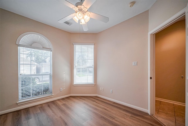 unfurnished room featuring visible vents, baseboards, ceiling fan, and wood finished floors