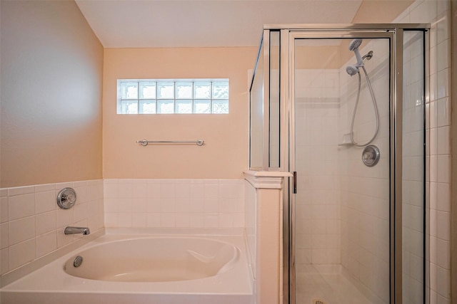 bathroom with a stall shower and a bath