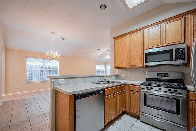 kitchen with a sink, backsplash, appliances with stainless steel finishes, light tile patterned flooring, and vaulted ceiling