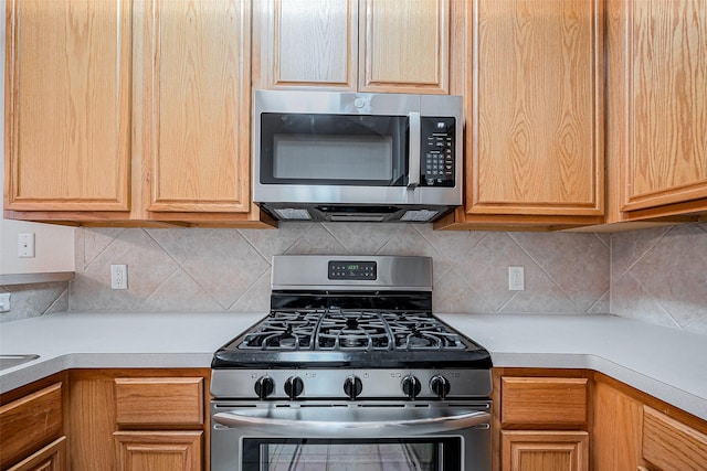 kitchen featuring light countertops, backsplash, and appliances with stainless steel finishes