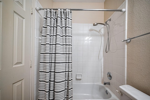 bathroom with toilet, a textured wall, and shower / tub combo with curtain