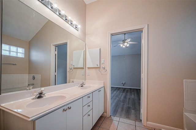 bathroom featuring tile patterned floors, a washtub, a ceiling fan, and a sink