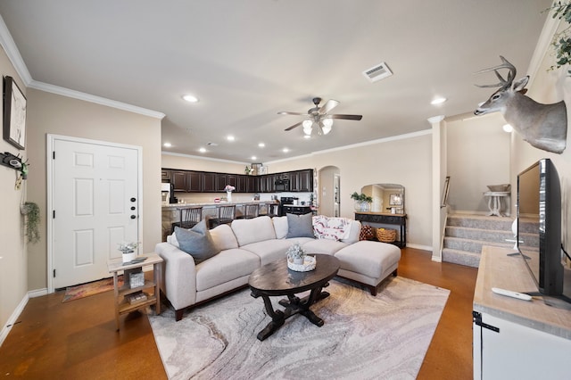 living room with arched walkways, visible vents, baseboards, stairs, and crown molding