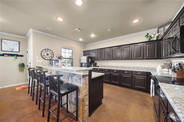 kitchen featuring a breakfast bar, recessed lighting, visible vents, finished concrete floors, and black appliances