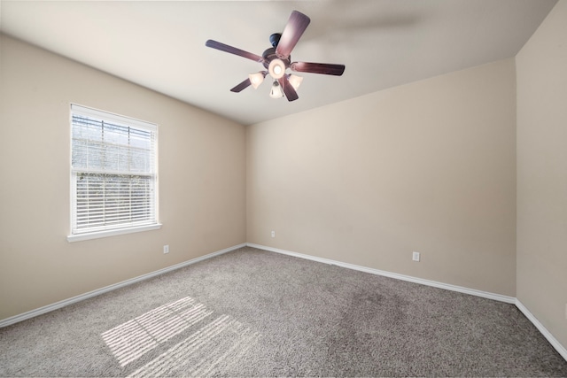 carpeted empty room with ceiling fan and baseboards