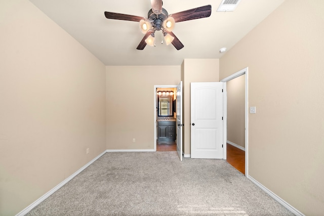 unfurnished bedroom featuring carpet, visible vents, ensuite bathroom, ceiling fan, and baseboards