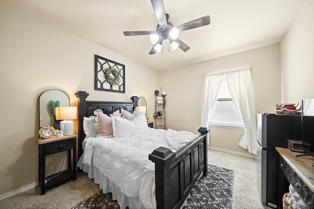 bedroom with light carpet, ceiling fan, baseboards, and freestanding refrigerator