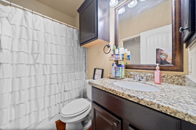 full bath with a shower with shower curtain, vanity, and toilet