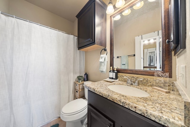 bathroom featuring toilet, curtained shower, and vanity