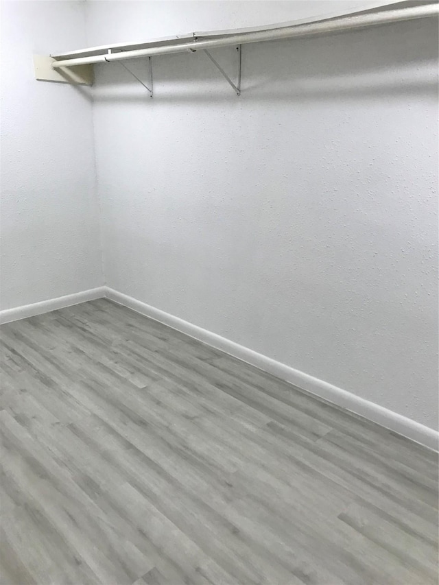 walk in closet with wood finished floors